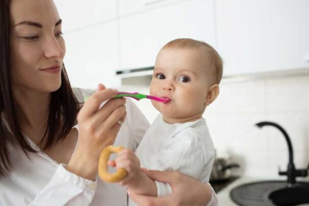 mother feed cute baby with spoon
